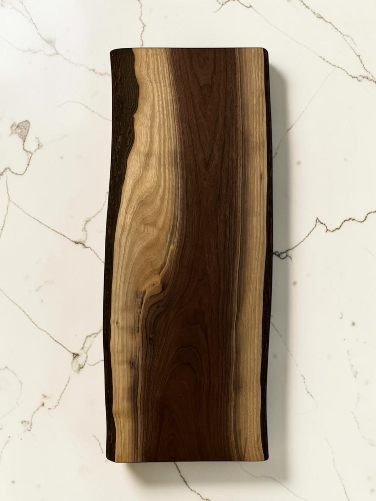 30 inch live edge walnut wooden charcuterie board photographed from directly above on a white marble surface.