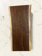 36 inch live-edge walnut charcuterie board  board displayed on a white marble surface.