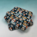 Three square coasters with rounded corners stacked slightly offset, featuring a colorful cartoon dog pattern on a dark blue background, set against a light blue gradient backdrop.