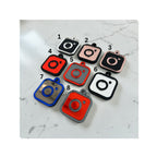 Eight Instagram social media tags on a light marble surface, numbered 1 through 8. The items come in different color combinations including black, red, rose gold, blue and grey