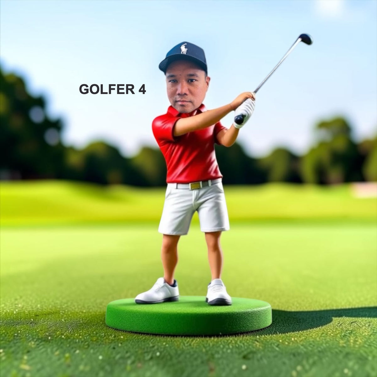 A golfer stands on a green circular base on a golf course. The golfer wears a navy cap with a white logo, a red polo shirt, white shorts, and white shoes, and is swinging the golf club. Style Golfer 4.
