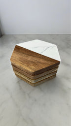 A stack of 4 hexagonal coasters displayed on a white marble surface.